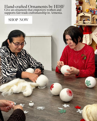 Two women making handcrafted ornaments with text about fair-trade craftsmanship in Armenia.